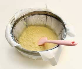 牛乳で煮詰めたカリンをザルと布でこす