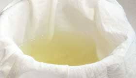 鍋で煮たカリンの種子と皮をザルでこしたものを布でこしているところ