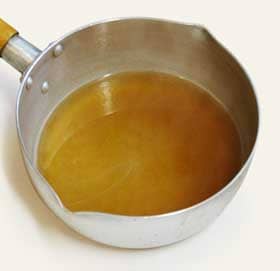 三温糖を加えて煮て、飴色になってきた鍋で煮たカリンの種子と皮からできたカリン・ジュース